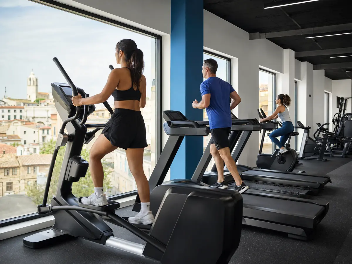 Vista conceptual de la zona de cardio con cintas y bicicletas